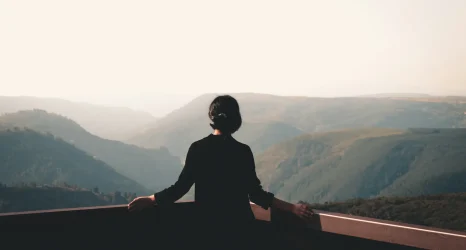 a-c-Lw9foG_-jRg-unsplash Person meditating while overlooking mountains.