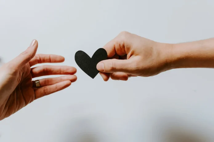 kelly-sikkema-XX2WTbLr3r8-unsplash Hands passing a heart-shaped object between each other.